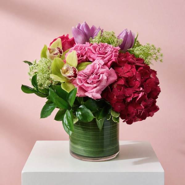 Pink and red floral arrangement in a glass vase