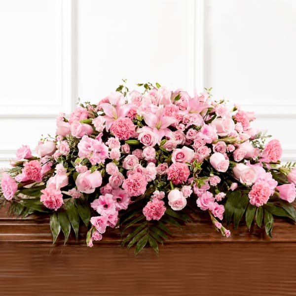 Pink floral casket spray with roses, carnations, and lilies