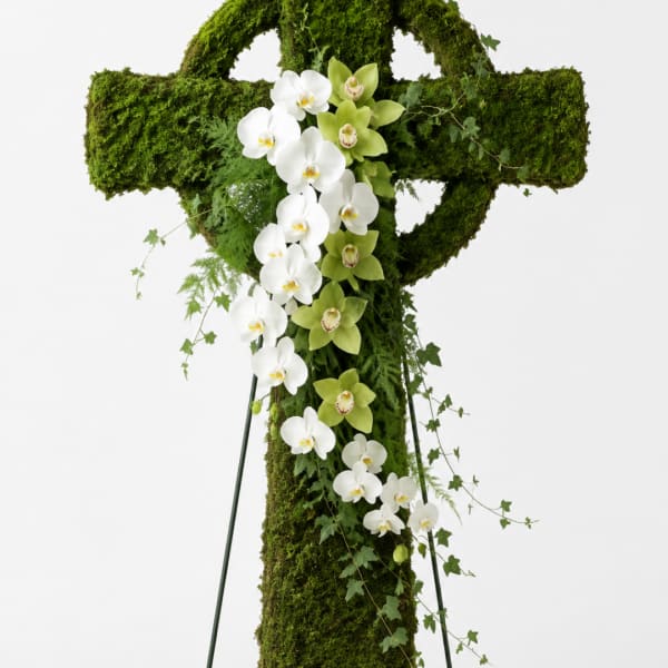Moss-covered standing cross with white and green orchids