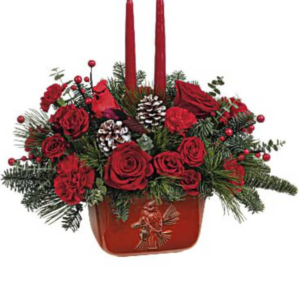 Red rose arrangement with two tall red candles in a red container
