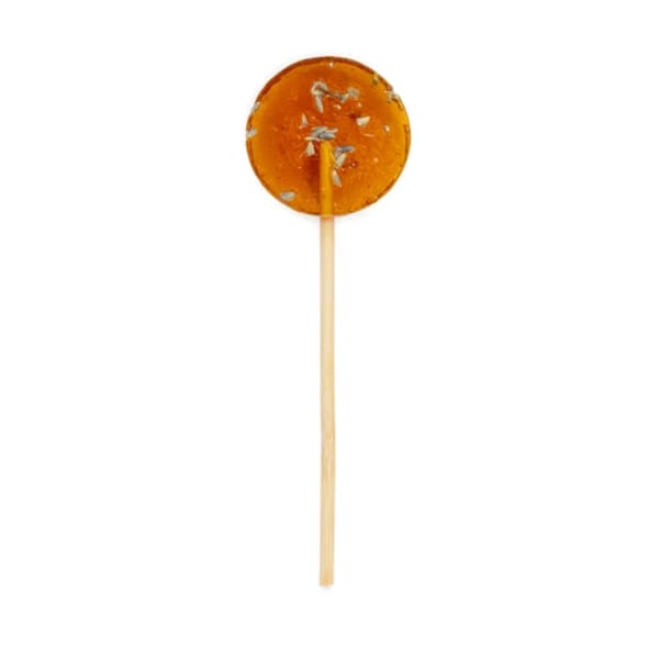 Orange round lollipop on a wooden stick