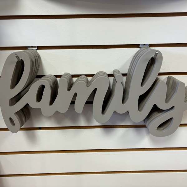 Gray layered wooden "family" wall sign on a slatwall display