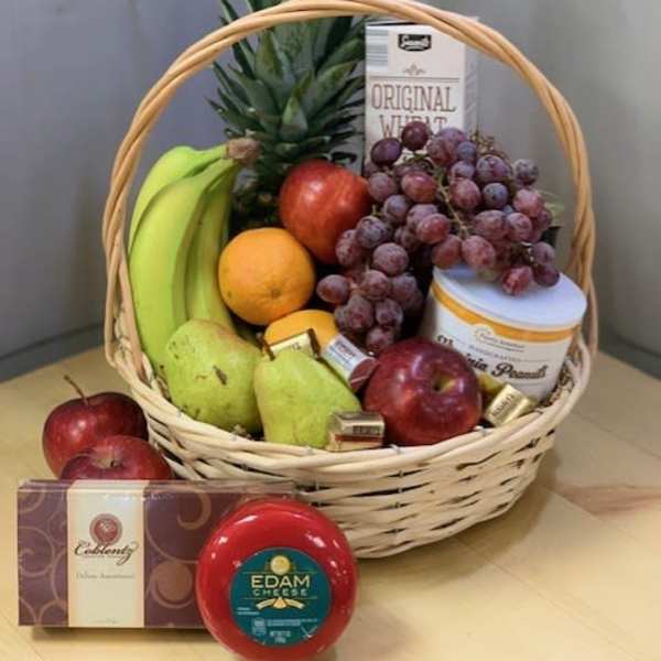 Fruit basket with bananas, grapes, apples, pears, pineapple, cheese, and chocolates
