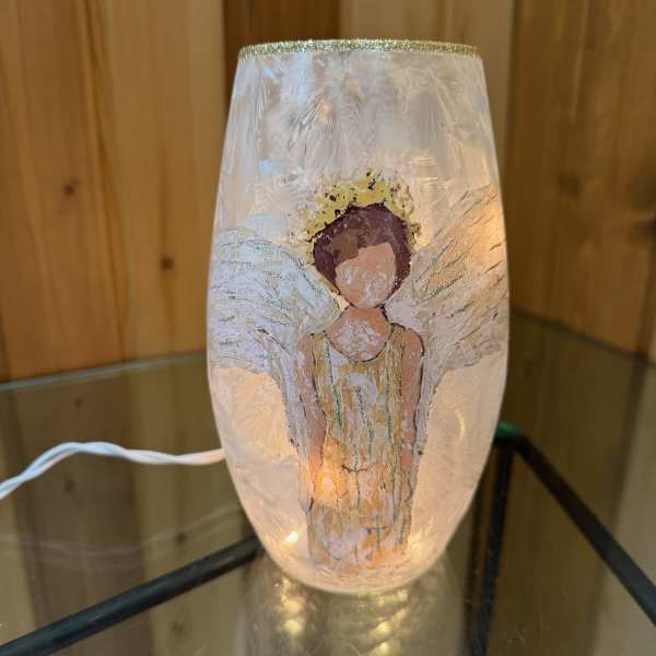 Decorative glass lamp with an angel figure inside