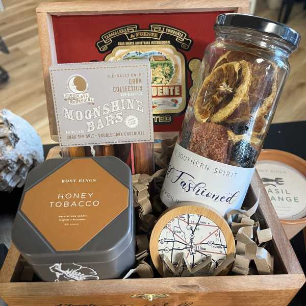 Gift basket with candles, chocolates, and a jar of dried fruit