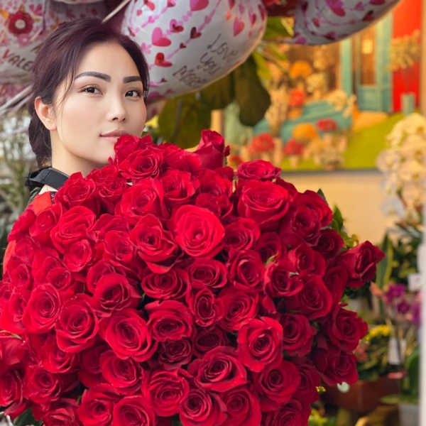 Woman holding a large bouquet of red roses