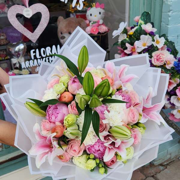 Large pink and white bouquet with lilies and roses wrapped in white paper