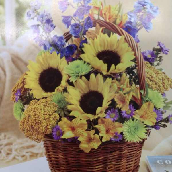 Basket arrangement with sunflowers, purple flowers, and yellow blooms