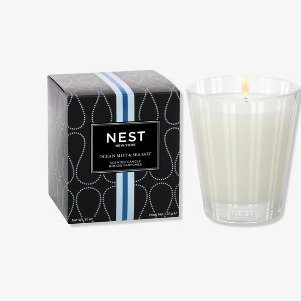 Scented candle in a clear glass tumbler beside its box