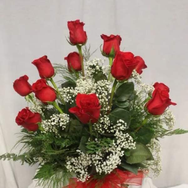 Bouquet of red roses with baby's breath in a glass vase