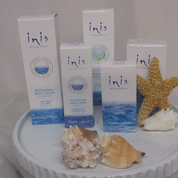 Innis skincare boxes arranged with seashells and a starfish on a round display
