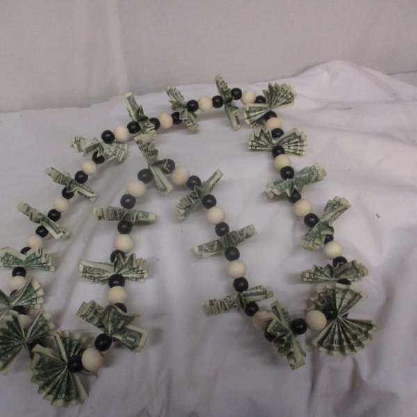 Beaded garland with folded dollar bills on a white cloth
