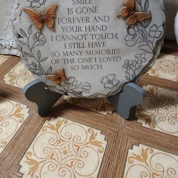 Memorial stone with floral line art and butterfly accents on a stand