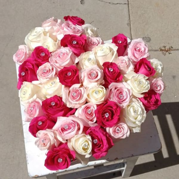 Heart-shaped bouquet of pink, white, and red roses