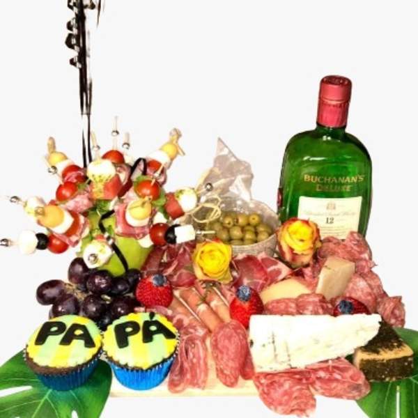 Gift tray with a yellow balloon, liquor bottle, cupcakes, and assorted snacks