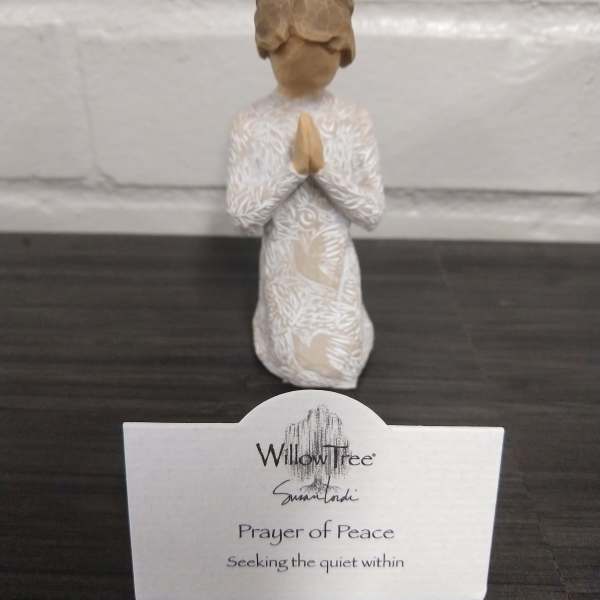 Small praying figurine with a card reading Prayer of Peace