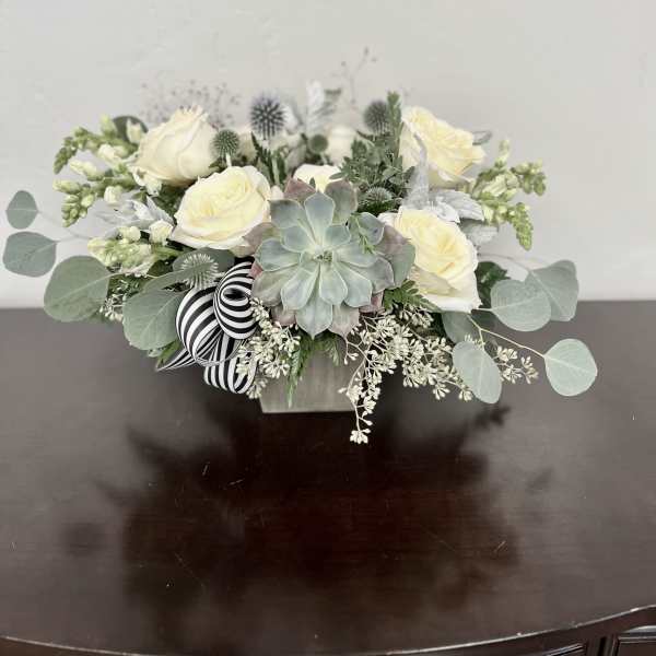 White rose arrangement with a succulent in a low square container