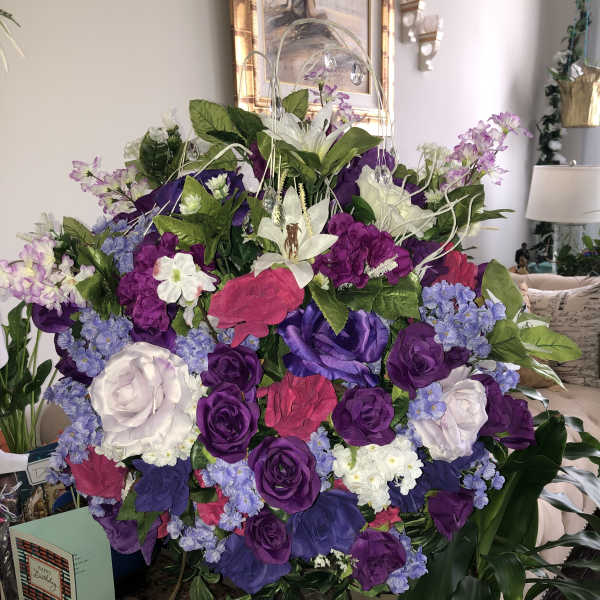Large bouquet of purple, pink, white, and blue flowers in a glass vase