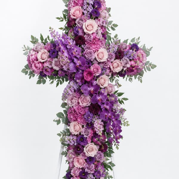 Purple and pink floral cross on a white stand