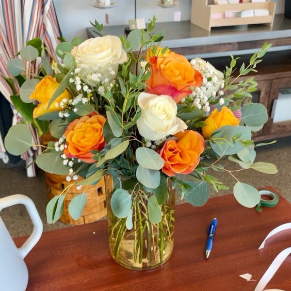 Bouquet of orange and white roses in a glass vase