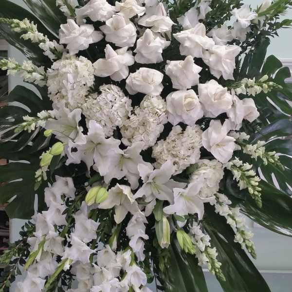 Large white floral standing spray with lilies and hydrangeas