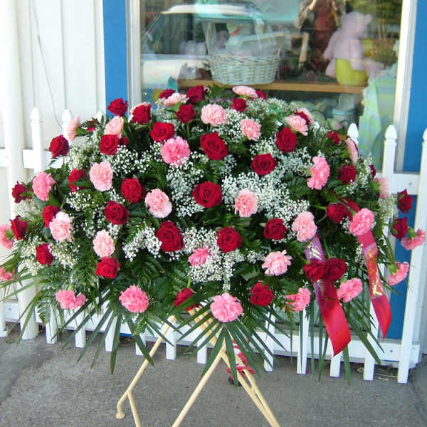 Large standing spray of red roses and pink carnations