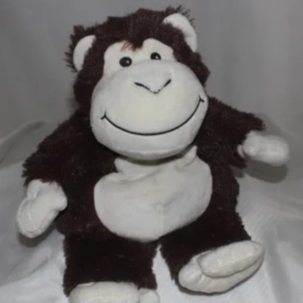 Plush monkey toy with a smiling face and white hands and feet