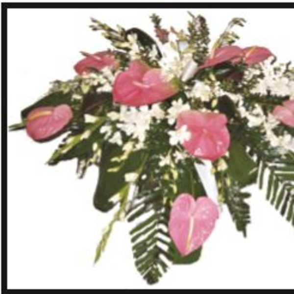 Pink anthuriums and white flowers in a low arrangement