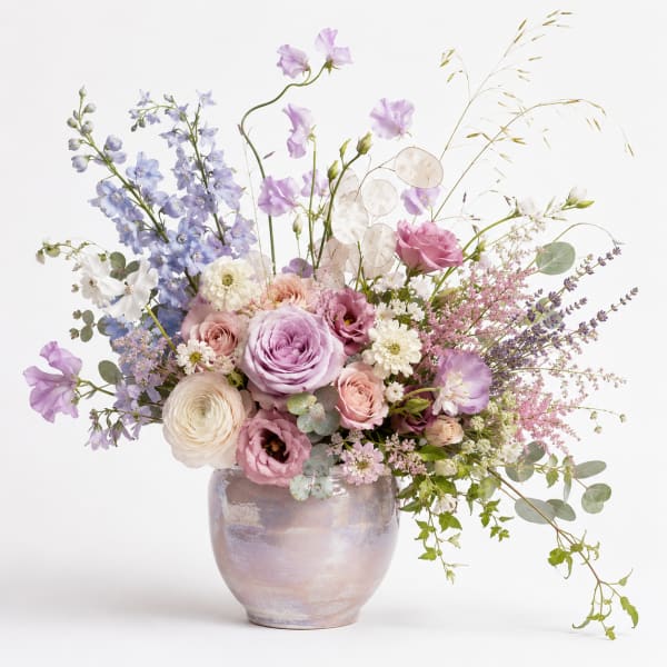 Pastel bouquet of roses, ranunculus, and lisianthus in a ceramic vase