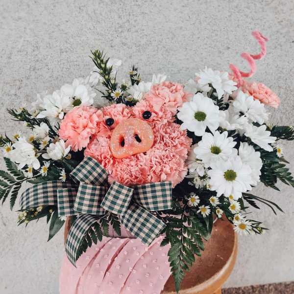 Pink floral arrangement with a pig face centerpiece and white daisies