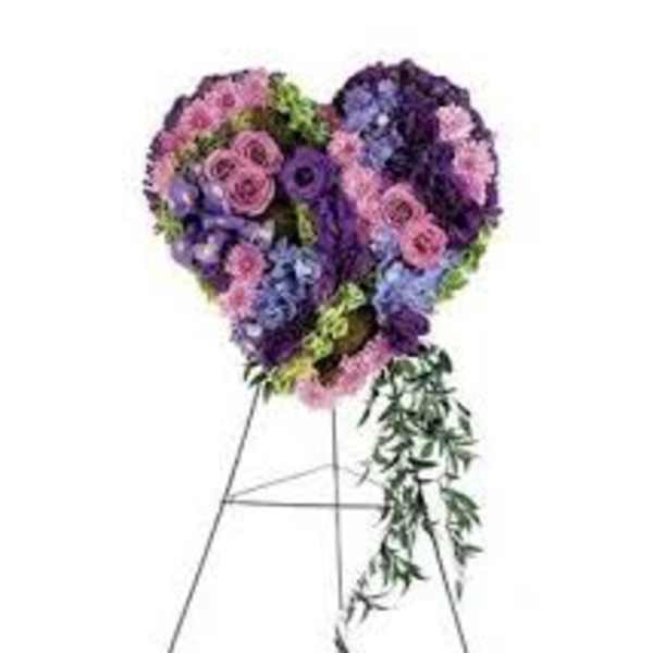 Heart-shaped floral standing spray on an easel with purple and pink flowers