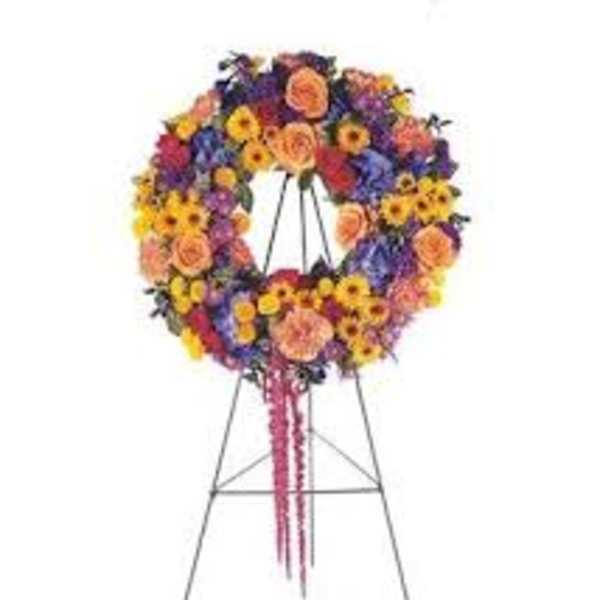 Colorful floral wreath on a standing easel with pink ribbons