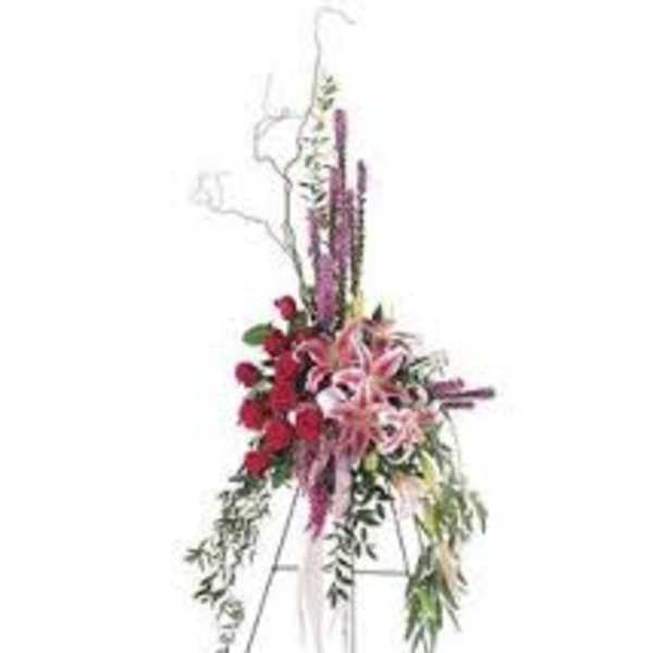 Tall floral standing spray with red and pink flowers on an easel