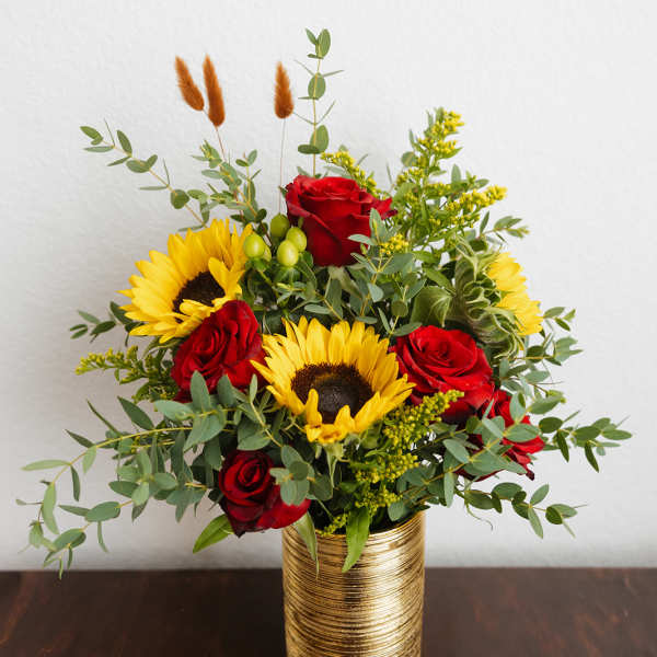 Red roses and sunflowers in a gold vase