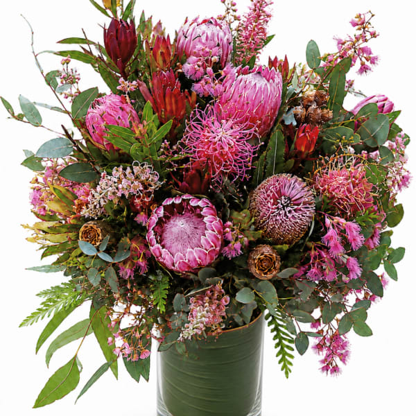 Large bouquet of pink protea and mixed blooms in a green vase
