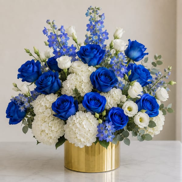 Blue roses and white blooms arranged in a gold vase