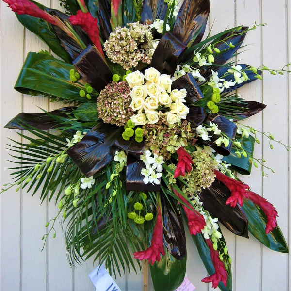 Large tropical floral spray with white roses and red blooms on a stand
