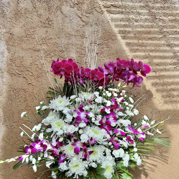 Basket arrangement of white chrysanthemums and magenta orchids