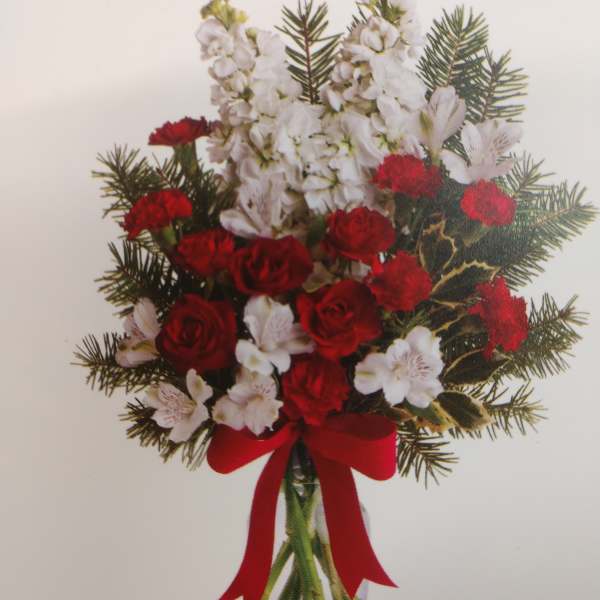Red roses and white flowers in a clear vase with a red ribbon
