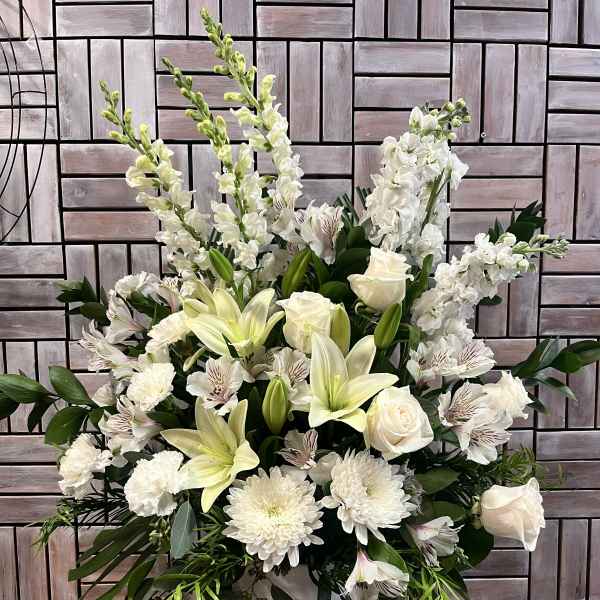 White floral arrangement with lilies, roses, and chrysanthemums in a vase