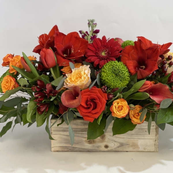 Mixed red and orange flowers in a wooden box arrangement