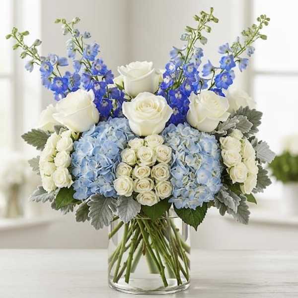 Blue and white floral arrangement in a clear glass vase