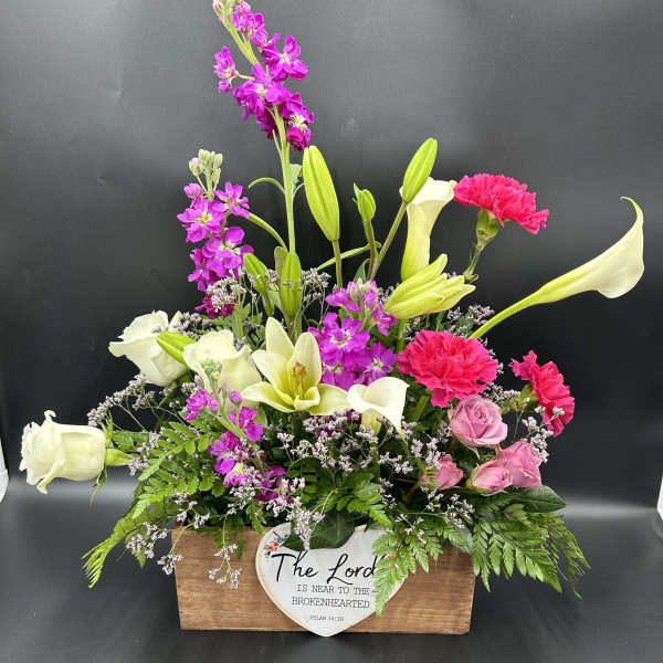 Mixed bouquet in a wooden box with white calla lilies, pink roses, and magenta blooms