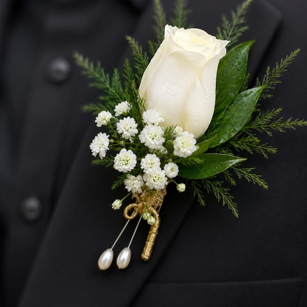 White rose boutonniere with small white flowers on a black jacket