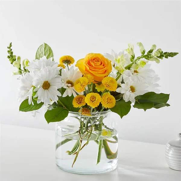 Yellow rose and white daisy bouquet in a clear glass vase