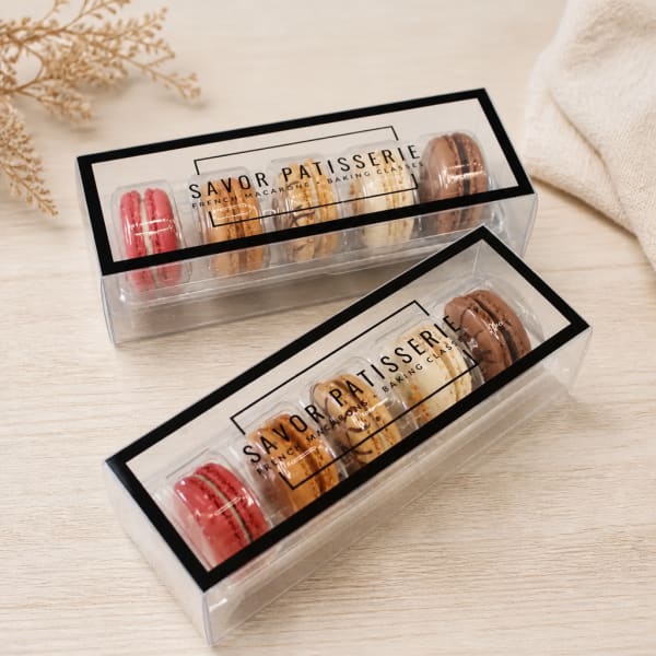 Two boxes of assorted macarons in clear plastic packaging