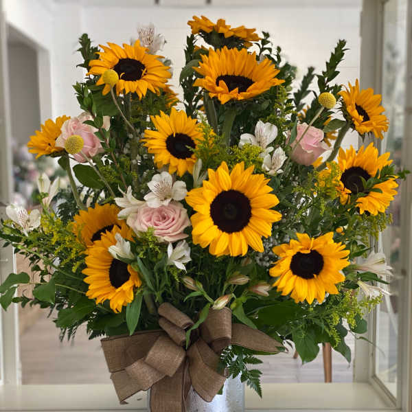 Sunflower bouquet with pink roses in a silver vase