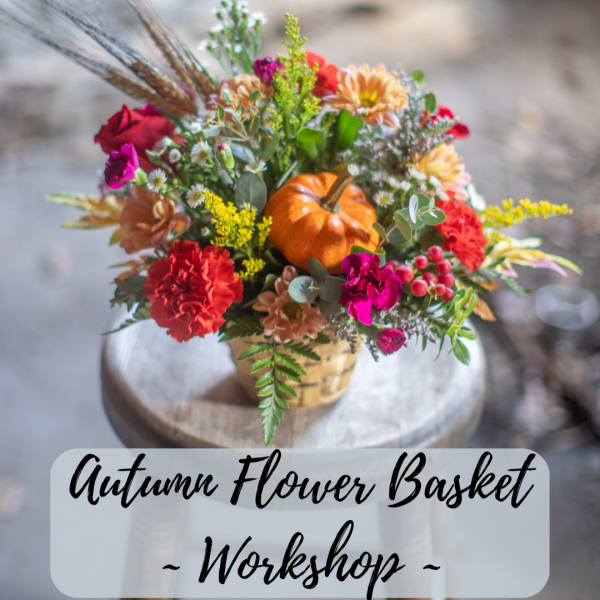 Autumn flower basket with mixed blooms and a small pumpkin in a basket