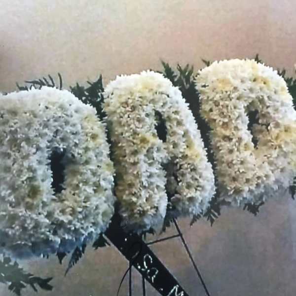 White floral letters with dark greenery accents