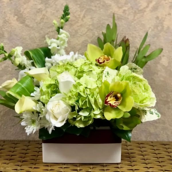 Green and white floral arrangement in a rectangular box